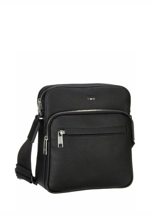 Sort skuldertaske i læder med tekstureret overflade, udstyret med en lynlåslomme foran og justerbar rem. Sølvfarvede metaldele.