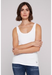 Top de tirantes de algodón blanco con escote redondeado y tirantes delgados, que presenta un sutil acento de logo en el dobladillo y un diseño ajustado.