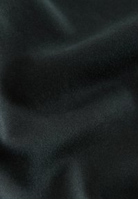 Black fabric with a soft, smooth texture and a slight sheen. The surface shows subtle ripples, indicating a lightweight and flexible material.