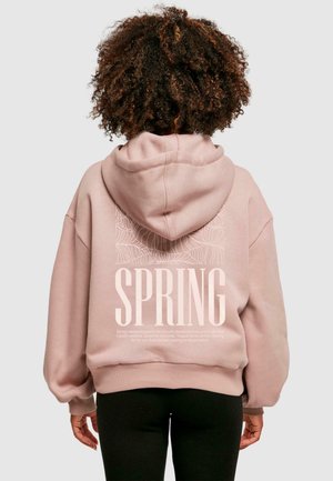 Helle rosa Kapuzenjacke mit Kapuze, die auf der Rückseite großen weißen Text "SPRING" und botanische Linienkunst zeigt. Weicher Stoff und lockere Passform.