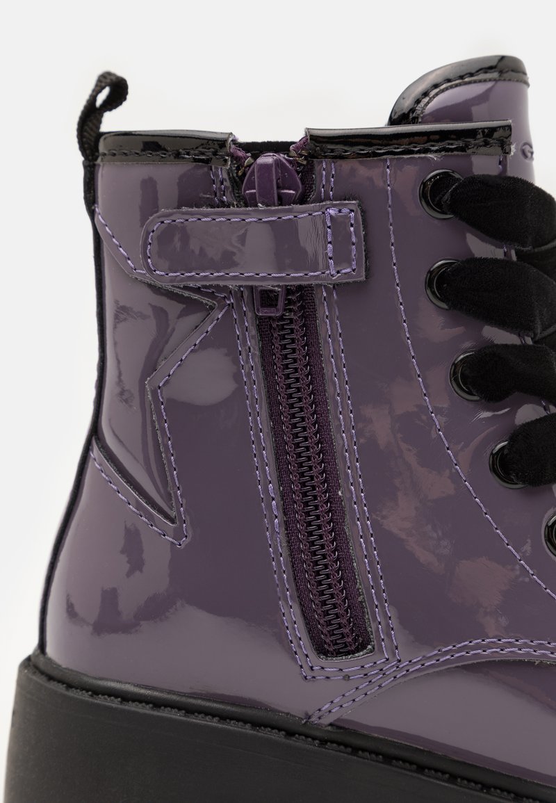 Lila Lackleder-Stiefelette mit strukturierten Oberflächen, seitlichem Reißverschluss, schwarzen Schnürsenkeln und einem kontrastierenden Sternmotiv an der Außenseite.