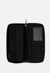 Portafoglio in pelle nera con chiusura a zip, dotato di molteplici scomparti per carte, una finestra trasparente per l'ID e una texture liscia. Vista dell'interno aperto.
