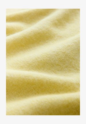 Blød, struktureret stof i en lys gul farve med en glat, let fuzzy overflade og subtile variationer i nuancen.