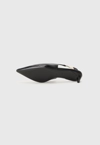 Escarpins slingback en cuir noir avec un bout pointu, un design courbé et un talon fin. Présentation d'un détail découpé et d'un accent en doré.