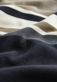 Material cu dungi, în nuanțe de bleumarin închis, bej și crem, cu lățimi variate; textura moale și detaliile cu coaste adaugă interes vizual.