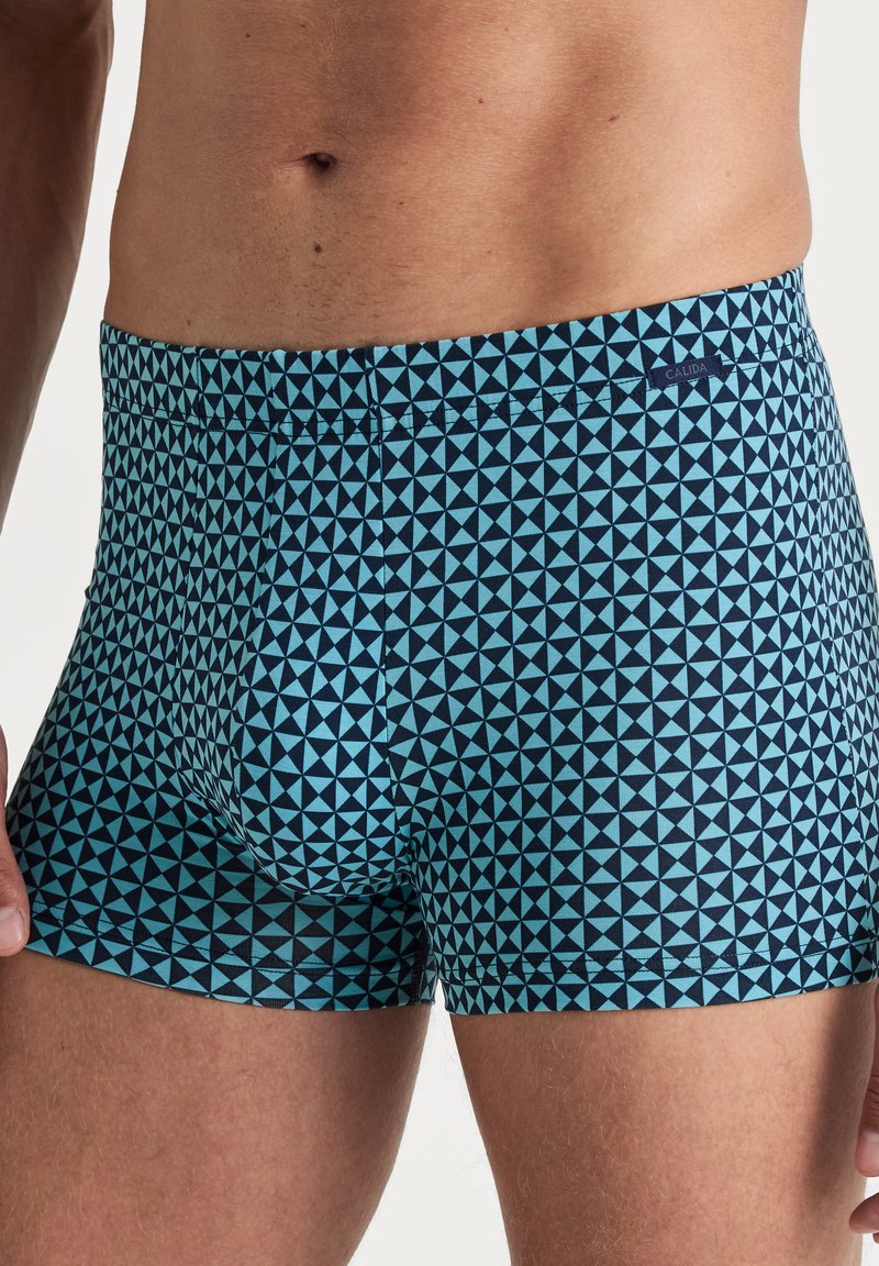 Herenboxershorts in een geometrisch blauw en marineblauw patroon, gemaakt van zachte stof. Heeft een slim fit en een elastische tailleband.