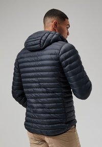 Jūras spēku puffer jaka ar kapuci, ar horizontālu quilted rakstu, gludu tekstūru un regulējamiem piedurkņu galiem siltumam un komfortam.