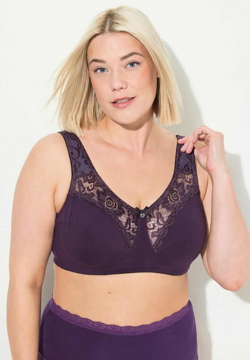 Soutien-gorge violet avec des détails en dentelle au niveau de l'encolure, orné d'un accent de bouton, doté de larges bretelles et d'un tissu lisse. Conçu pour le confort et le soutien.