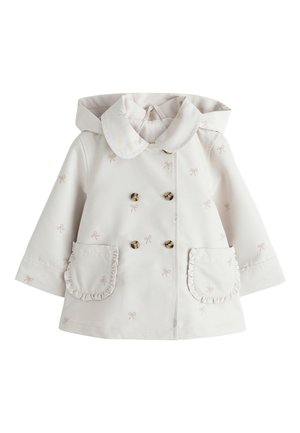 Krém színű kiscipős kapucnis kabát peter pan gallérral, dupla gombsorral, kis masni mintákkal és fodros első zsebekkel.