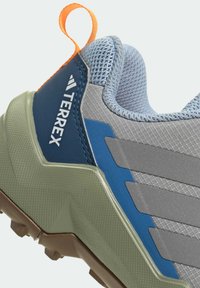 Grå og blå herre løbesko med en struktureret mesh-overdel, gummiydersål og orange trækkebånd. Har et lagdelt design for støtte.