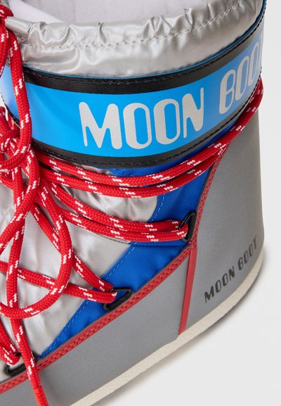 Moon Boot grigio e blu con colletto imbottito, lacci rossi e una superficie liscia. Marchio "Moon Boot" su una cinghia blu.