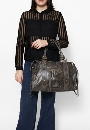 Graue Lederhandtasche mit strukturiertem Finish, oberen Tragegriffen, dekorativer Hardware und einer Frontreißverschlusstasche. Enthält lange Quastendetails.