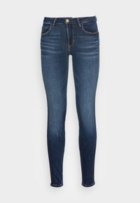 Jeans ajustados fabricados en denim azul oscuro, con bolsillos frontales, cierre de botón y detalles de costura sutiles a lo largo de las costuras.