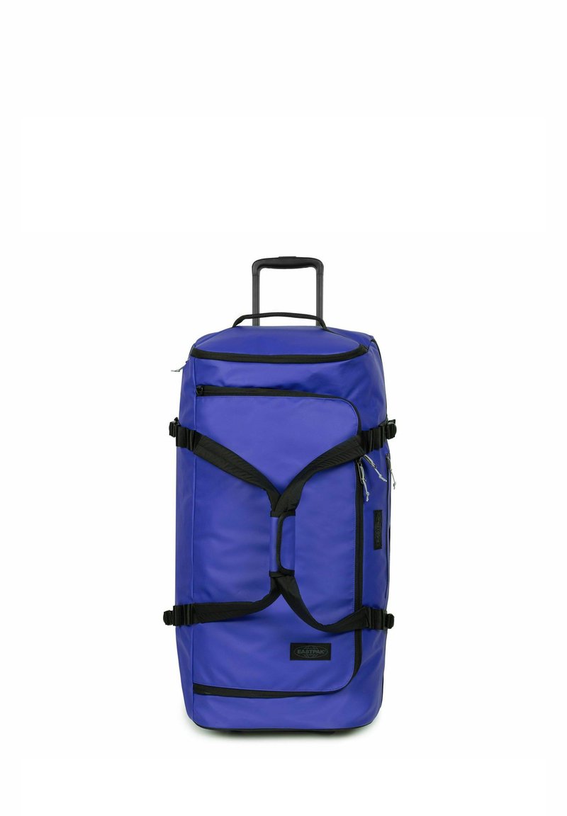 Große blaue Reisetasche mit ausziehbarem Griff, schwarzen Trägern und Reißverschlüssen. Verfügt über mehrere Fächer und eine strukturierte Stoffoberfläche.