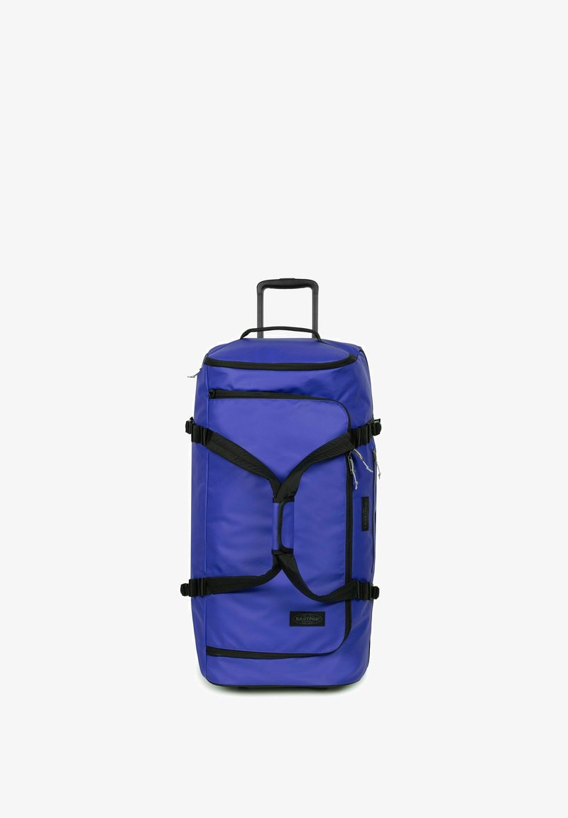 Große blaue Reisetasche mit ausziehbarem Griff, schwarzen Trägern und Reißverschlüssen. Verfügt über mehrere Fächer und eine strukturierte Stoffoberfläche.