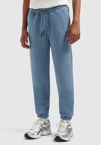 Lichtblauwe sweatpants met een elastische tailleband, boorden en zijzakken. Gemaakt van zachte stof, met verstelbare trekkoorddetails.