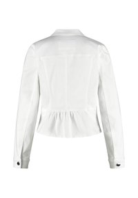 Weiße taillierte Jacke mit einem peplumförmigen Saum, langen Ärmeln und geknöpften Manschetten. Verfügt über eine Rückenpasse und dekorative Nähte. Glattes Material.