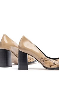 Escarpins en cuir verni beige avec un talon épais noir et un motif texturé imprimé serpent à l'avant. Forme à bout pointu.