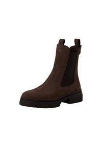 Bottine Chelsea en suede marron foncé avec des panneaux latéraux élastiques, des languettes et une semelle en caoutchouc noire épaisse sur fond blanc.