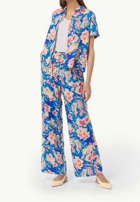 Bloemendessintoutfit met een kortgerafeld shirt en een wijdvallende broek in blauwe, roze en crèmekleuren. Zacht materiaal met een relaxte pasvorm.