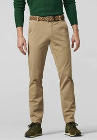 Beige chinos with a slim fit, featuring front pockets and a woven multicolored belt. Paired with dark green textured sweater and black sneakers.