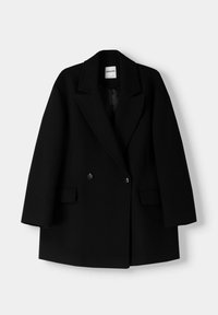 Svart dubbelknäppt kavaj med slagkragar, två framfickor med lock och knapppyssel, uppvisad mot en enkel bakgrund.