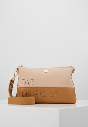 Sac à main bicolore beige et marron avec bandoulière amovible et texte perforé indiquant "LOVE YOURSELF" à l’avant.