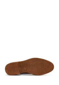 Braune Gummisohle mit strukturierter Oberfläche, geschwungener Form und einem kreisförmigen Logodetail in der Mitte. Die Kanten sind glatt und leicht erhöht.