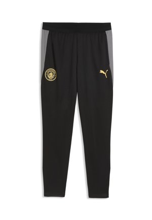 Sorte atletikbukser med grå sidepaneler, med et gyldent Manchester City-logo på venstre lår og et gyldent Puma-logo på højre lår.