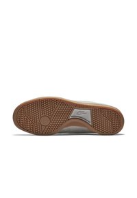 Nikeova potplate�ža, koja sadrži gumenu vanjsku podlogu s heksagonalnim uzorkom, glatki sivi gornji dio i Nike logo u središtu.