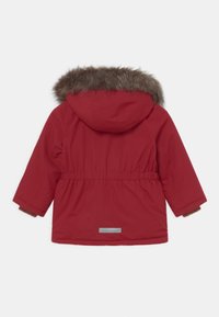 Parka rouge avec une capuche bordée de fourrure, une taille élastique et une bande réfléchissante à l'arrière. Comprend des manches longues avec des poignets en maille.