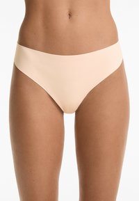 Beige bikini slipjes van gladde, rekbare stof. Het ontwerp heeft een hoge uitsnijding bij de benen en een naadloze tailleband voor comfort.