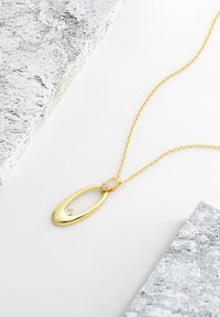 Gul vedhæng med oval design, der har en lille diamant og en tekstureret detalje; forbundet med en delikat kæde.