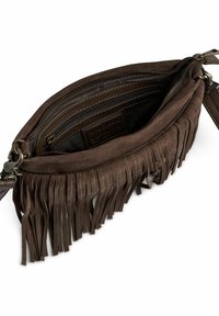 Barna velúr crossbody táska, amelyet frufru díszít az alján, belső cipzáras zsebekkel és sima cipzárral záródik.