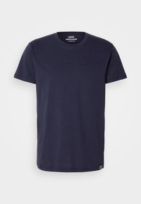 Marineblå bomuld t-shirt med rund halsudskæring, korte ærmer og lige snit. Har en lille stribet detalje på kanten.