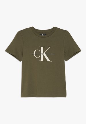 Camiseta de manga corta verde aceituna con cuello redondo y logo centrado "CK Calvin Klein Jeans" en letras grandes blancas y grises.