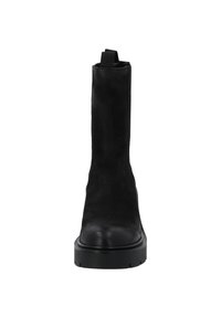 Bottine en cuir noir avec une finition texturée, bout rond, semelle plate et une languette en haut pour un enfilage facile.