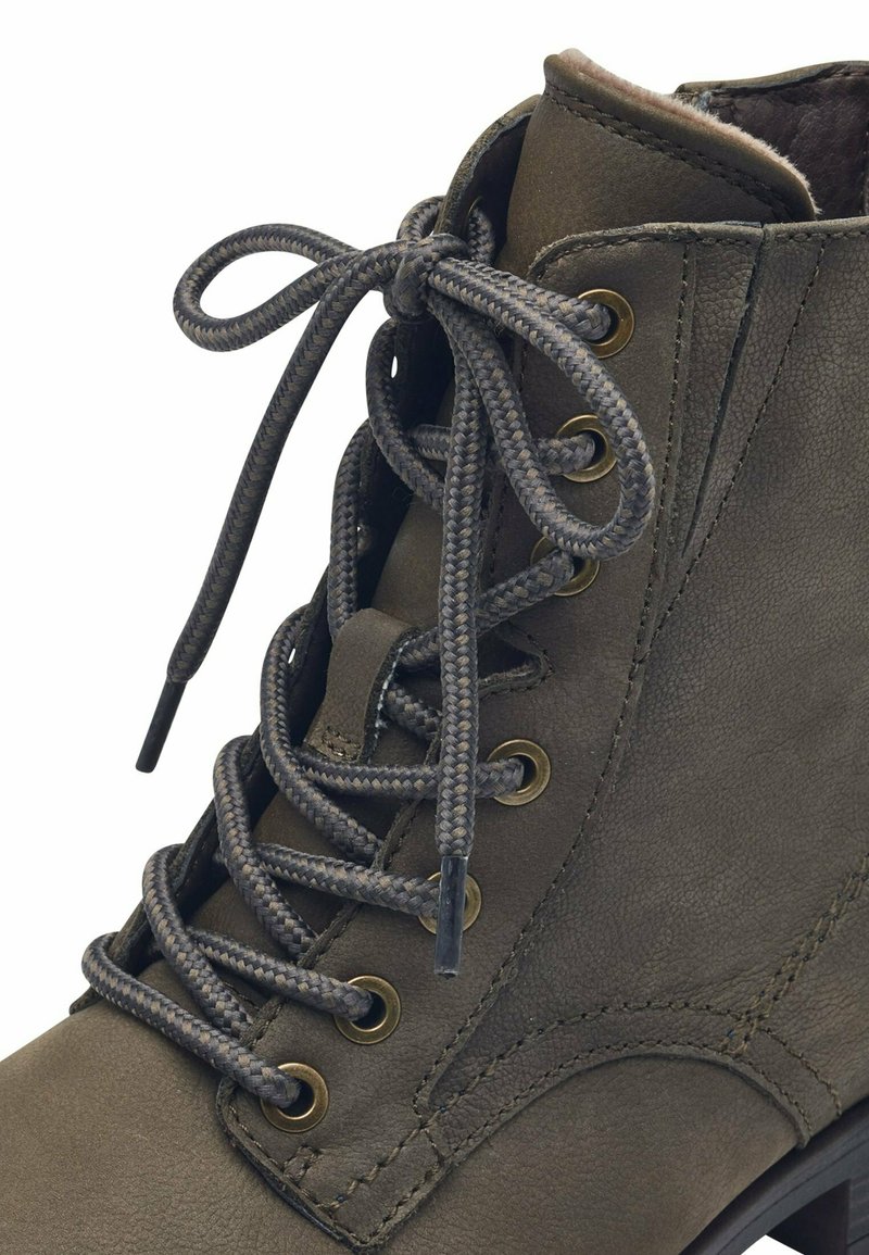 Botín de cuero color verde oliva con una textura suave, que presenta ojales metálicos, cordones trenzados y un cuello acolchado.