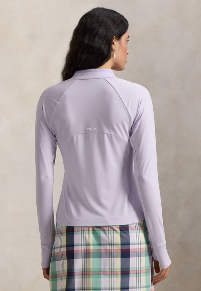 Ανοιχτό μωβ μπλούζα μακριάς μανίκιας με χαλαρή γραμμή, διαθέτει μανίκια ράγκλαν και ανάγλυφο λογότυπο "RLX" στην πλάτη, σε συνδυασμό με καρό φούστα.