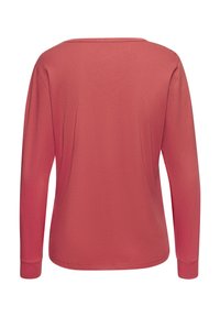 Langärmliges Shirt in einer Korallenfarbe aus weichem Baumwollstoff, mit rundem Halsausschnitt und gerippten Bündchen. Glatte Textur ohne Muster.