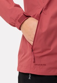 Rode, waterdichte jas met een ritszak aan de zijkant, verstelbare manchetten met klittenband en een textuurstof met ademende eigenschappen.