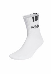 Calcetín Adidas blanco hasta la mitad de la pantorrilla con tres rayas negras y el logo negro de Adidas cerca de la parte superior.