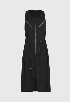 Robe noire sans manches avec fermeture éclair à l'avant, deux poches poitrine zippées, taille réglable avec cordon et fente sur le devant pour faciliter les mouvements.
