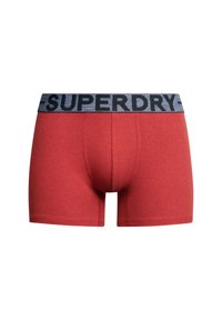 Czerwone bawełniane szorty bokserki z szarym elastycznym pasem, na którym widnieje słowo "SUPERDRY" w kolorze czarnym. Projekt jest prosty i dopasowany.