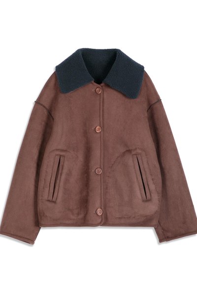 Veste en daim marron avec quatre boutons, deux poches devant et un grand col en polaire bleu marine foncé.