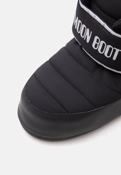 Близък план на черен подплатен Moon Boot с бели надписи и гумена подметка, предназначен за зимно носене и изолация.