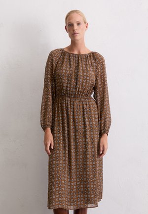 Braunes, langärmliges Kleid mit einem strukturierten Muster aus weißen und blauen Formen, ausgestattet mit einem elastischen Bund und einem lockeren Schnitt.