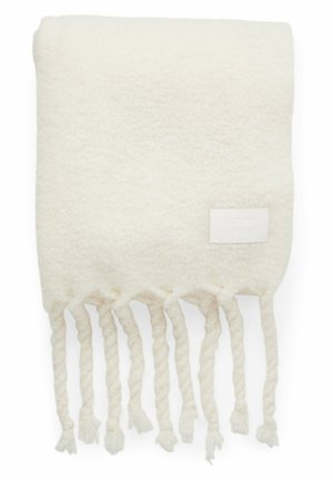 Zachte, roomkleurige wollen sjaal met gedraaide franjes aan de uiteinden en een klein rechthoekig stoffen label in één hoek.