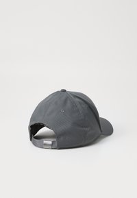Grå baseballkasket med en buet skygge, lavet af struktureret stof, med en justerbar strop bagpå med metalhardware og ventilationshuller.