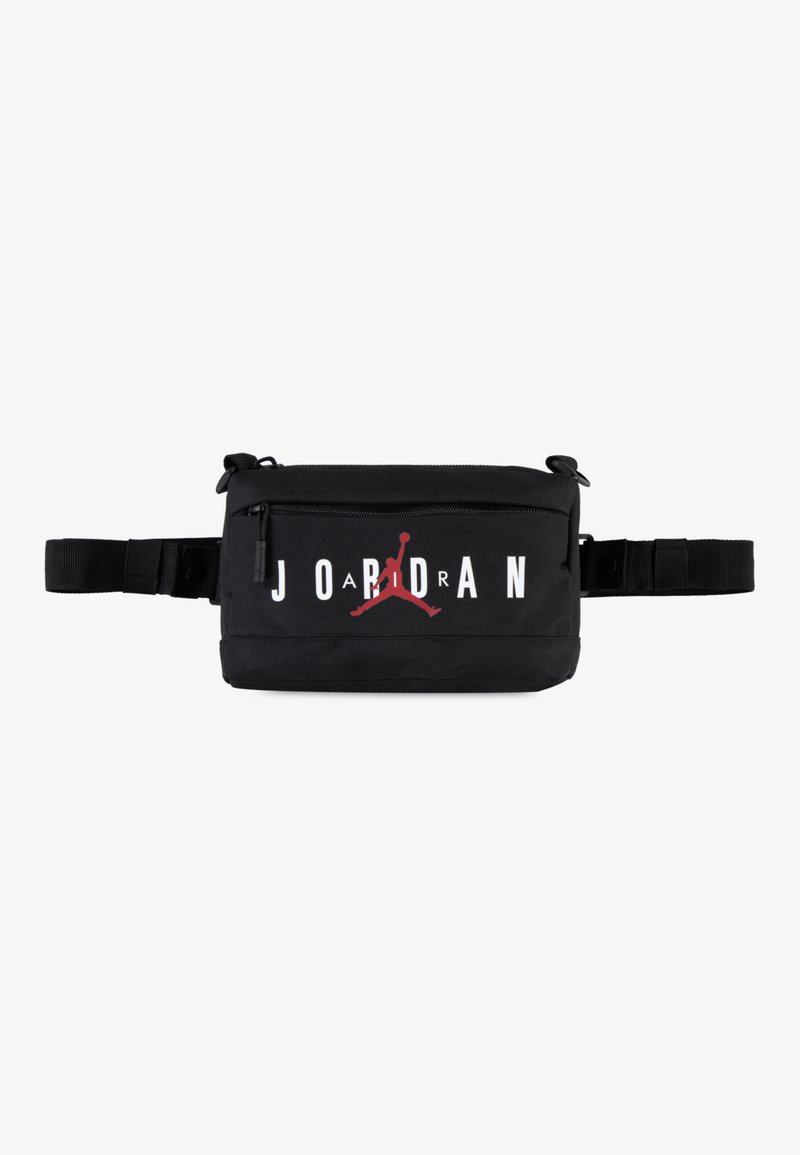Sacoche noire en tissu avec une sangle ajustable, affichant un logo blanc "JORDAN" et une silhouette Jumpman rouge sur le devant. Fermeture zippée.